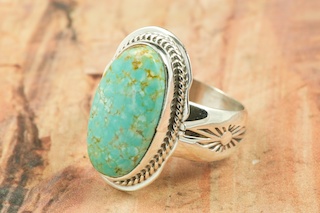 Genuine Number 8 Turquoise set in Sterling Silver Ring. The Number 8 mine is located in Eureka County Nevada. Since 1976 there has been no Number 8 Turquoise mined. There is however, an existing stock pile that Mr. Dowell Ward, the last owner of the Number 8 mine, had stocked away for later sorting. The Turquoise is a collector's item--because once the reserve is gone there will be no more material released onto the market. The Gold Mining Company owns the claim to the Number 8 mine and it has been swallowed up by the gold mining operations. This is some of the last Number 8 Turquoise to be had and will be a great addition to your collection. Created by Navajo Artist Lucy Valencia. Signed L. J. by the artist.